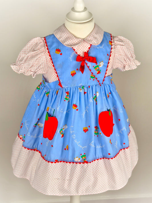 3 years. Blue, white and red "back to school" dress with apple pockets