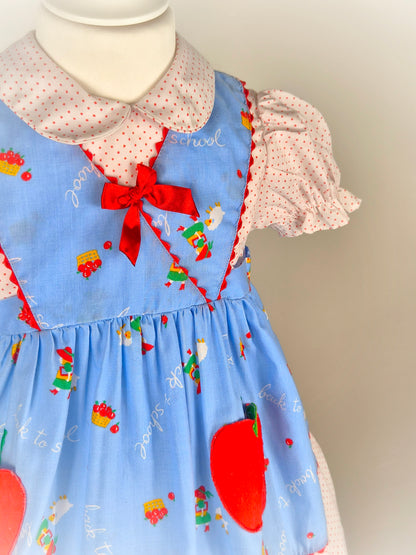 3 years. Blue, white and red "back to school" dress with apple pockets
