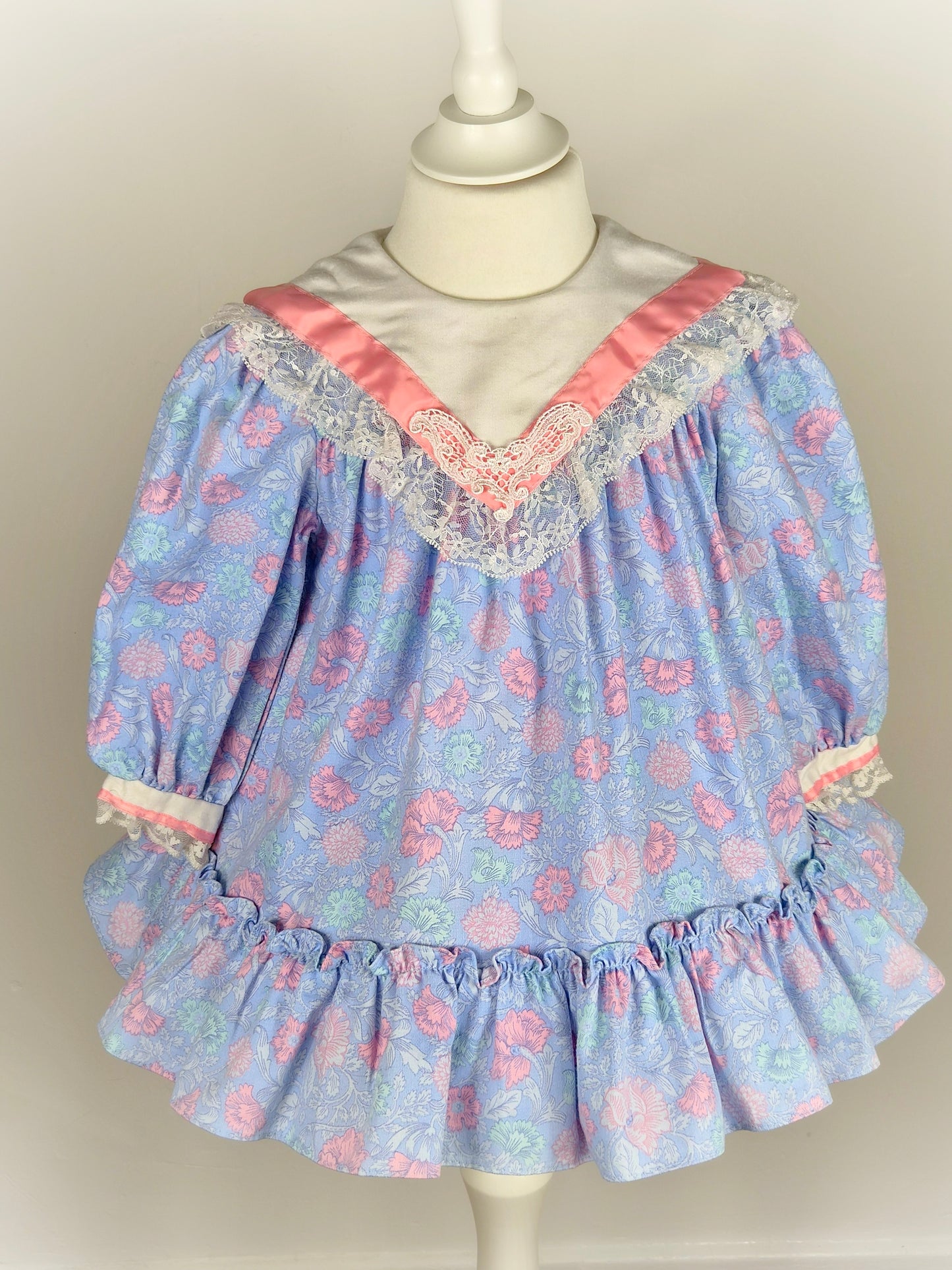 2-3 years. Vintage Polly Flinders dress with floral print, white lace trimmed bib and pink satin ribbon