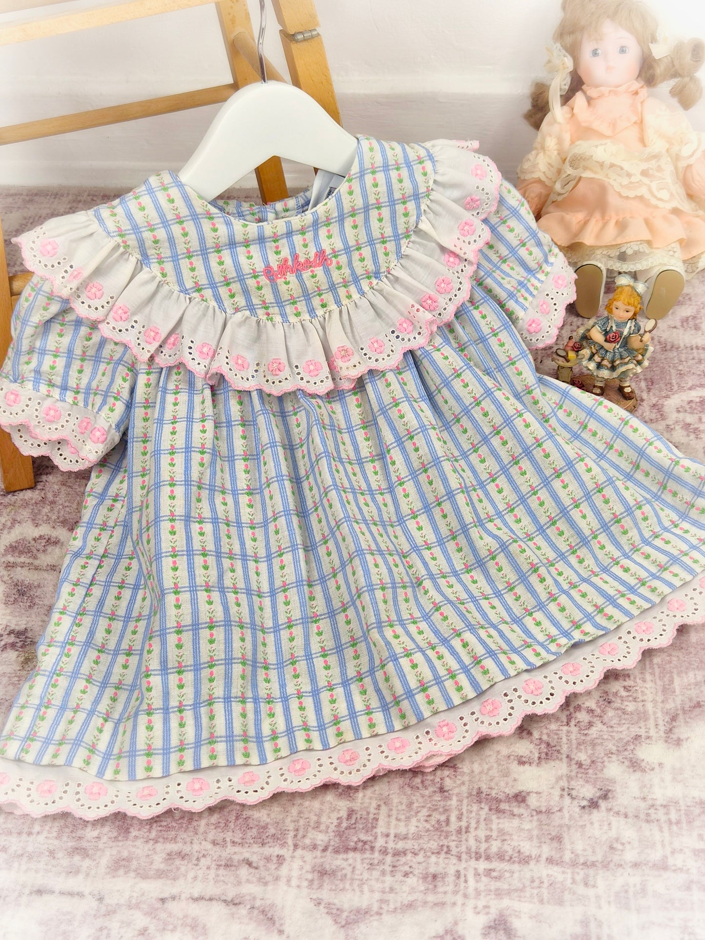 12-18 months. Blue checked Oshkosh dress with white frills, pink embroidered eyelet details and delicate flower print