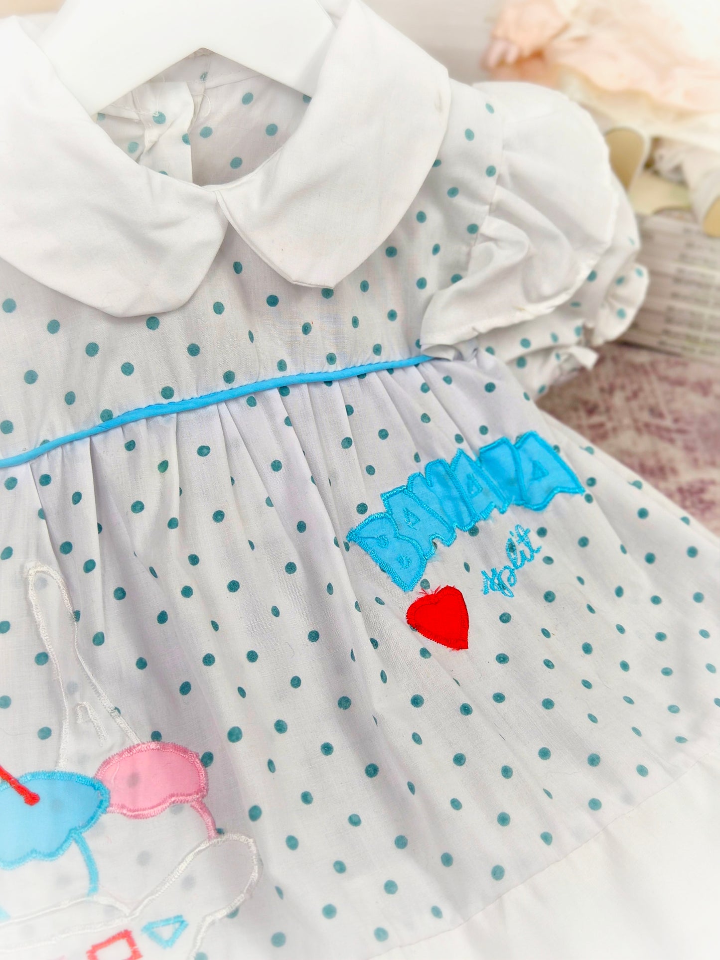 9-12 months. White vintage dress with blue polka dots, white peter pan collar and "banana split"