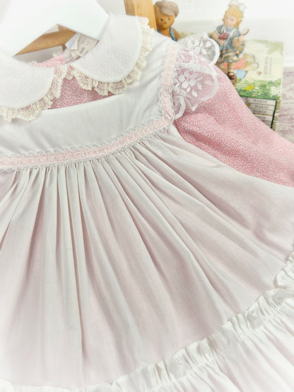 18-24 months. Two piece vintage Bryan, pink floral dress with white frilly apron trimmed with white lace and pink satin ribbon