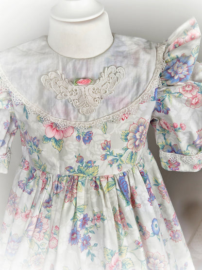 4-5 years. White vintage dress with floral design, puff sleeves, large bib and rosette