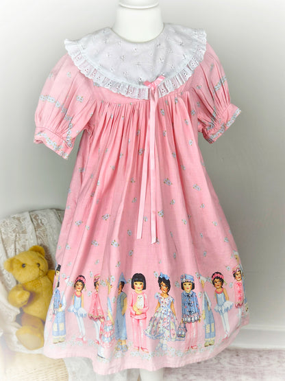 9-10 years. Pink floral vintage dress with multicultural girls, white eyelet bib and pink ribbon. See description*