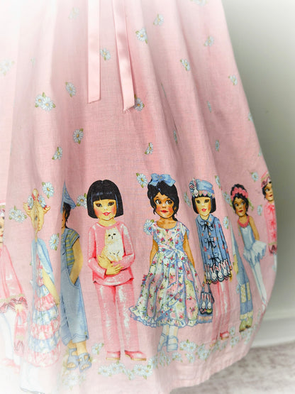 9-10 years. Pink floral vintage dress with multicultural girls, white eyelet bib and pink ribbon. See description*