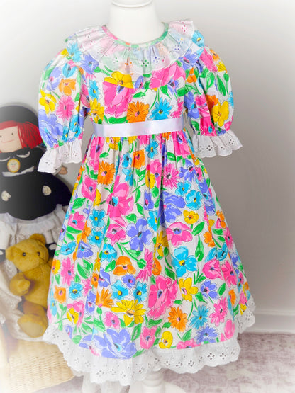 7-8 years. Pretty floral vintage dress with white eyelet collar and hem and puff sleeves