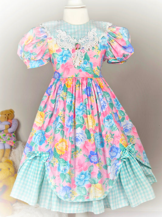 5 years. Pink floral vintage dress with mint and white gingham bib, hem and bows, puff sleeves and lace bib