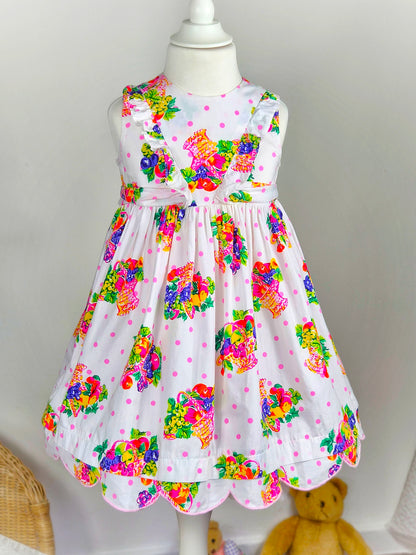 3 years. White sleeveless dress with bright fruit print and scalloped hem