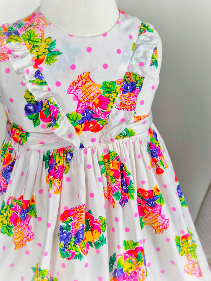 3 years. White sleeveless dress with bright fruit print and scalloped hem
