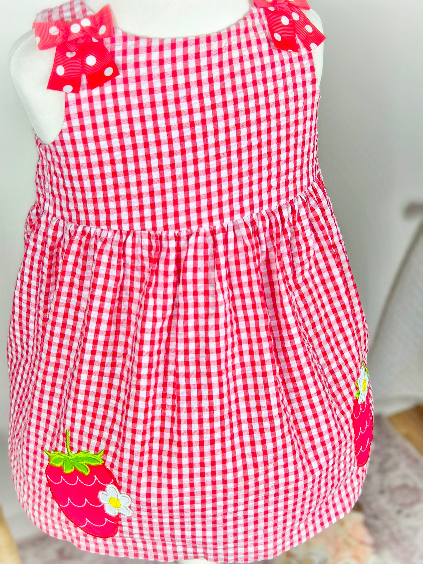 2 years. Red and white sleeveless gingham dress with red polka dot bowsand strawberry appliques