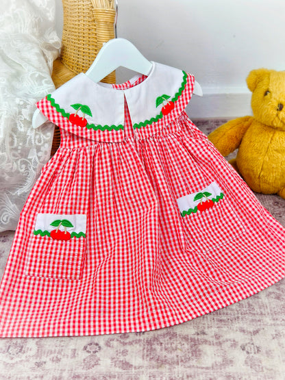 2 years. Red and white sleeveless vintage Samara dress with large collar and pockets adorned with cherries