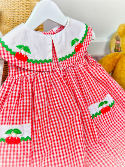 2 years. Red and white sleeveless vintage Samara dress with large collar and pockets adorned with cherries