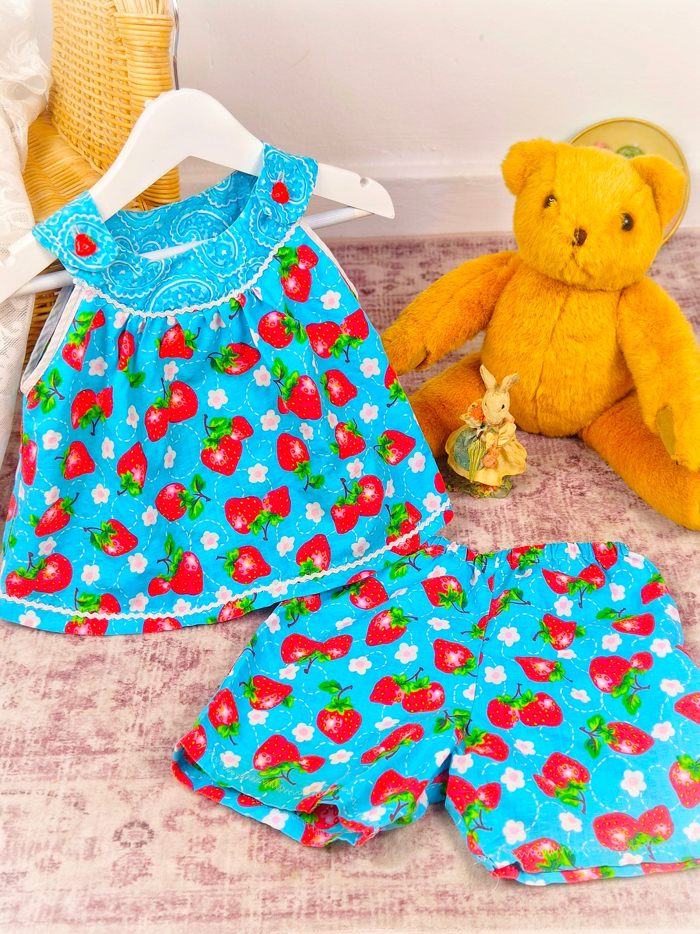 3 years. Two piece set, blue sleeveless top with matching shorts, strawberry print and dainty buttons