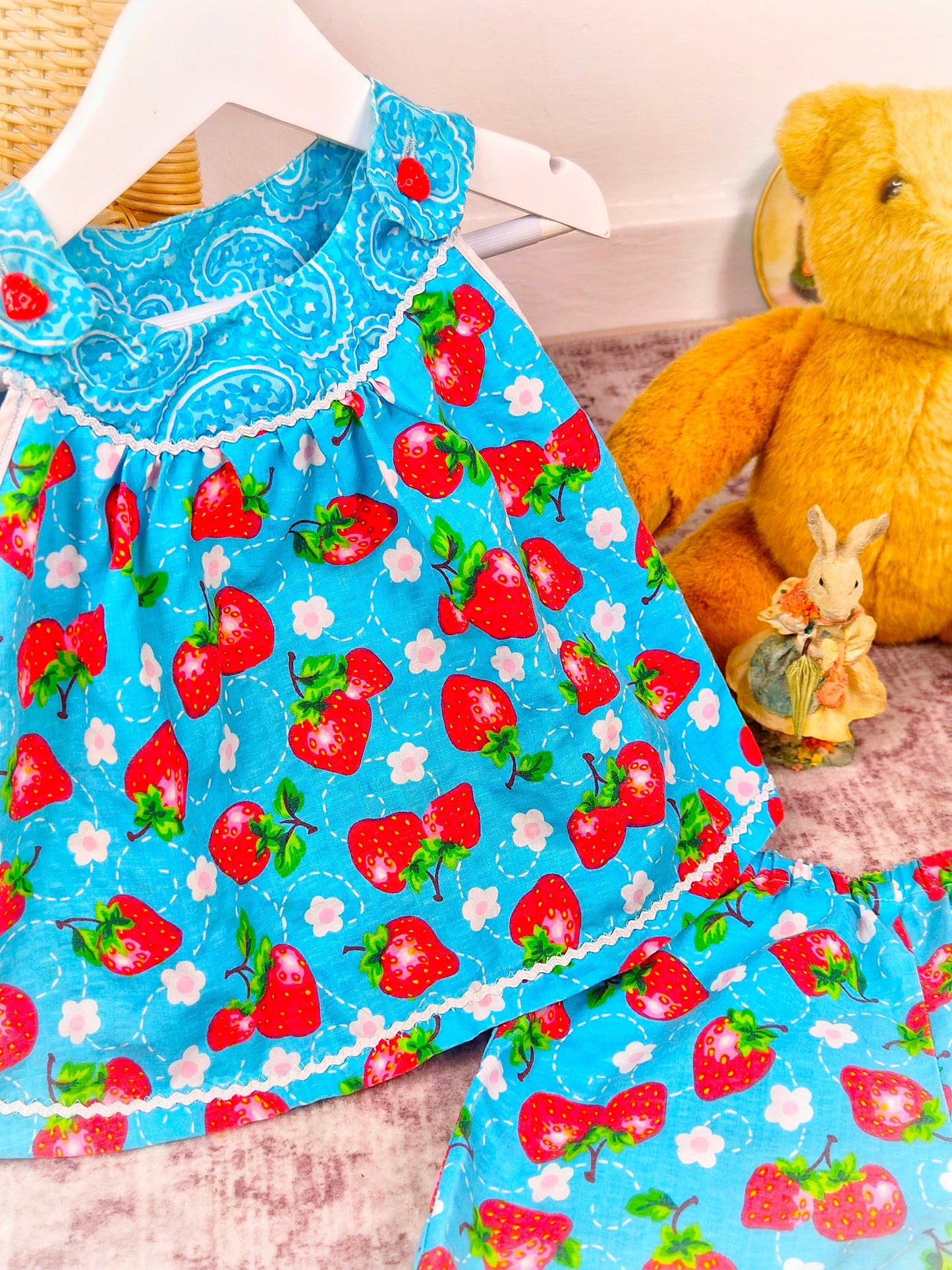 3 years. Two piece set, blue sleeveless top with matching shorts, strawberry print and dainty buttons