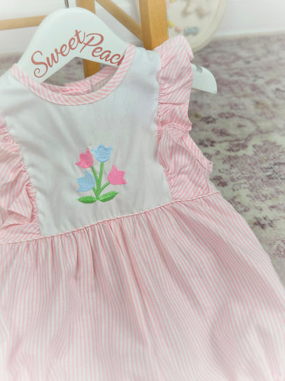 9-12 months. Pink and white striped, sleeveless Alexis romper with frills and embroidered flowers