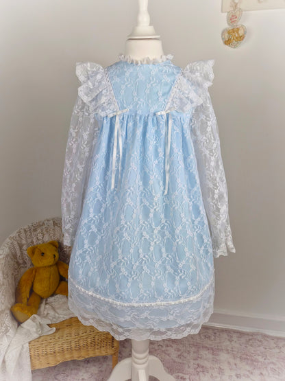 6 years. Blue vintage dress with white lace overlay, flutter shoulders and ribbon bows
