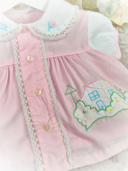 0-3 months. Pink and white vintage dress with embroidered house and flowers and lace details