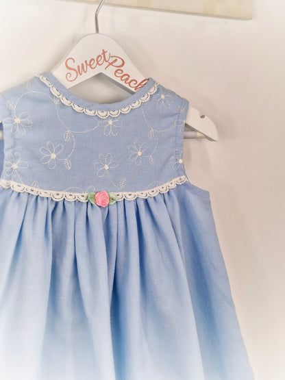 2 years. Blue sleeveless dress with white details and pink rosette