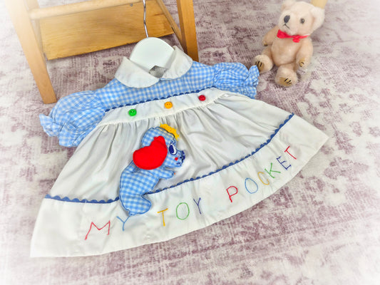 0-3 months. Vintage dress with embroidered "My Toy Pocket", stuffed dog toy and little button details