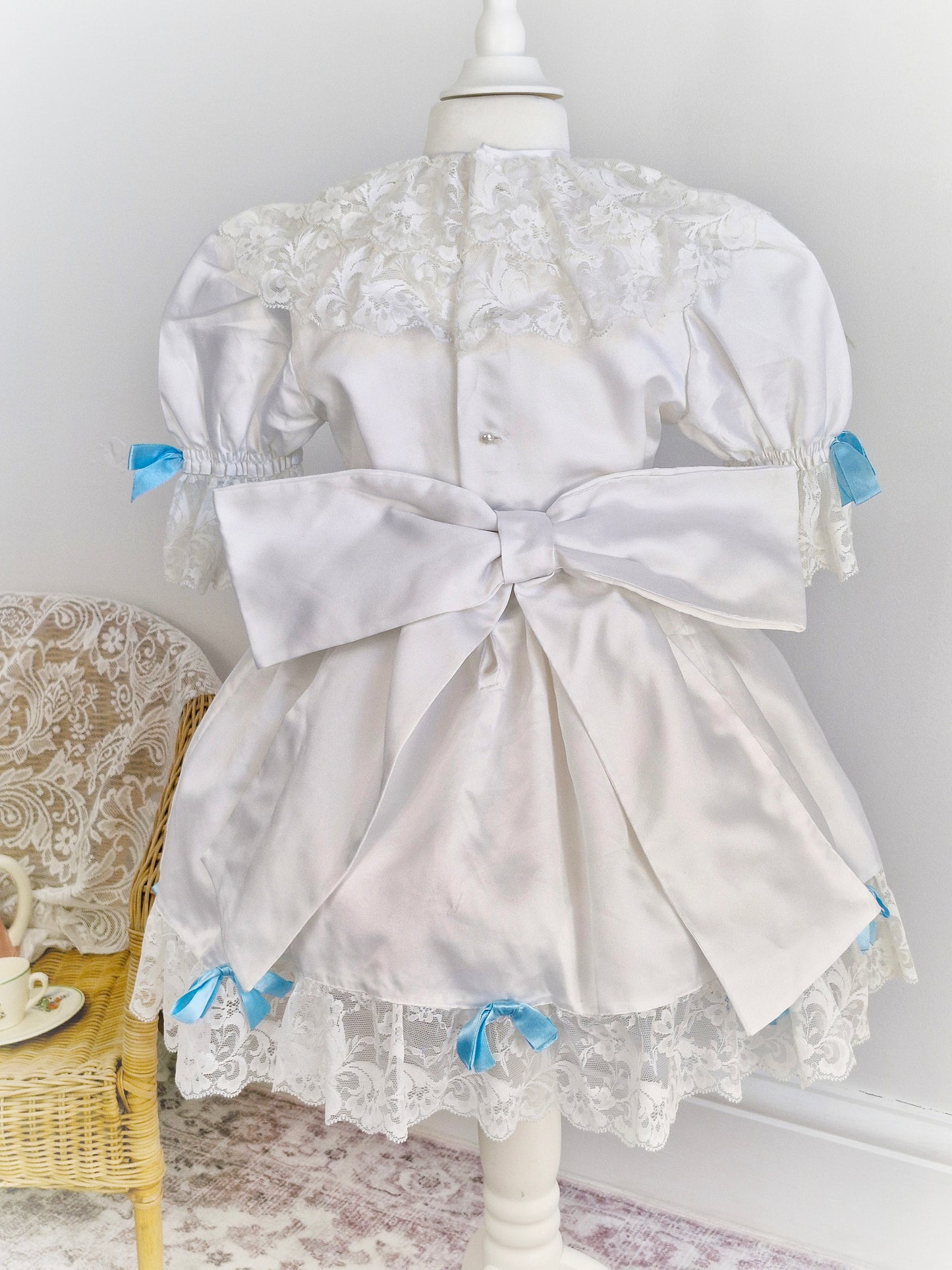 4-5 years. White satin dress with lace and blue ribbon