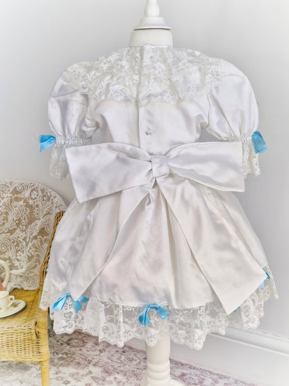 4-5 years. White satin dress with lace and blue ribbon