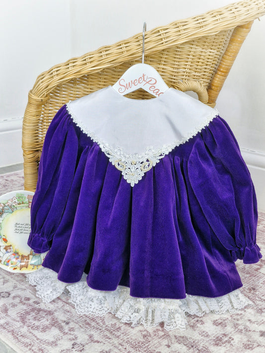 2 years. Deep purple velour Bryan dress with white lace hem and bib with pearl details