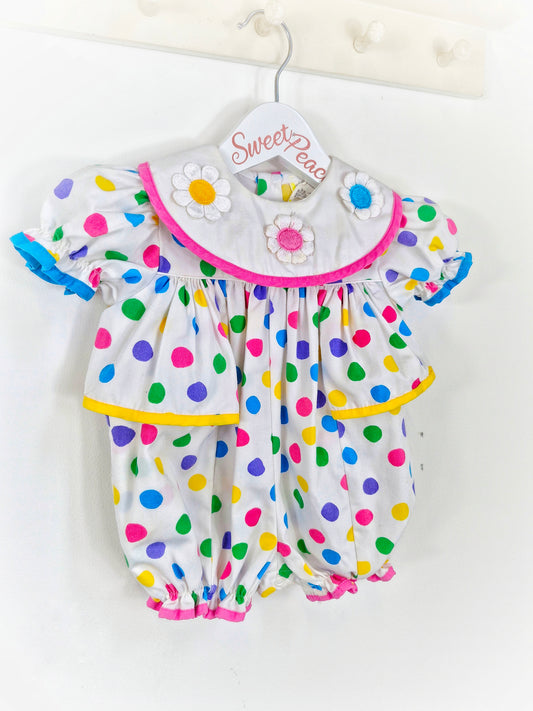 9-12 months. White romper with bright coloured spots and flowered bib
