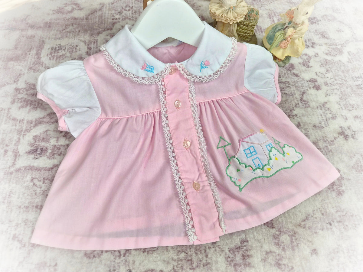 0-3 months. Pink and white vintage dress with embroidered house and flowers and lace details
