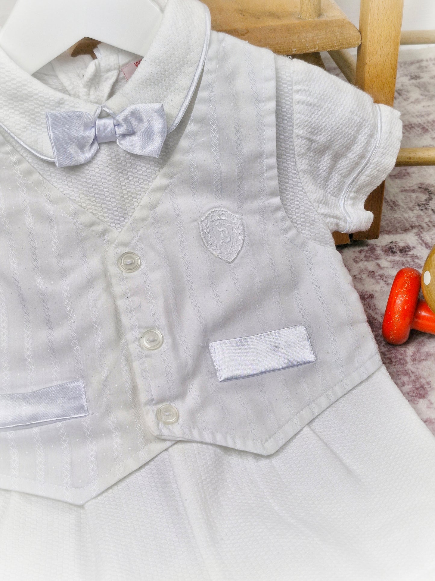 9-12 months. White one-piece romper, waistcoat and bow tie style