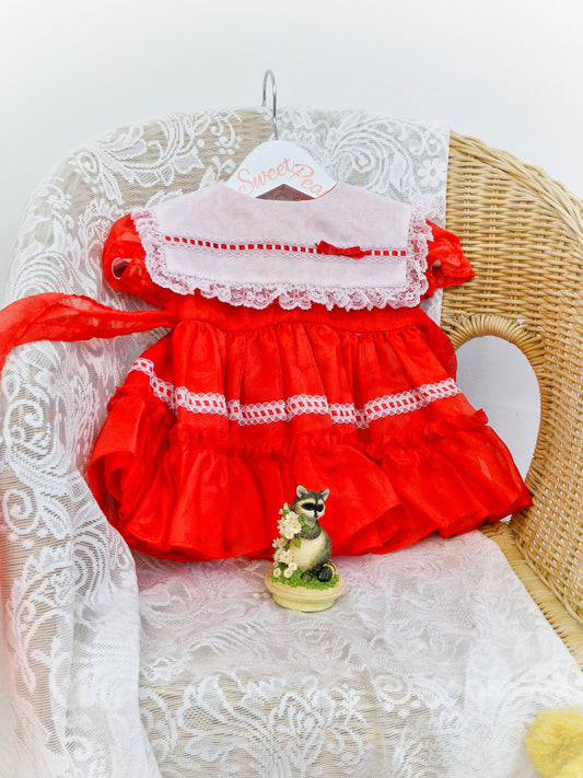 6-9 months. Red Kandy Ann dress with white bib and lace, red ribbon.