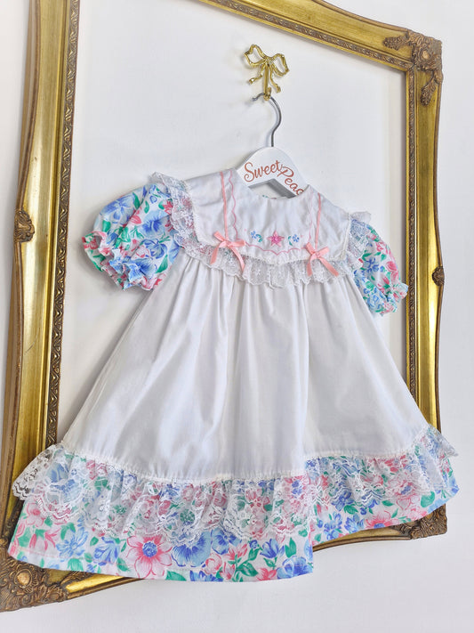 2 years. White dress with floral details and lace. Embroidered bib with ribbon