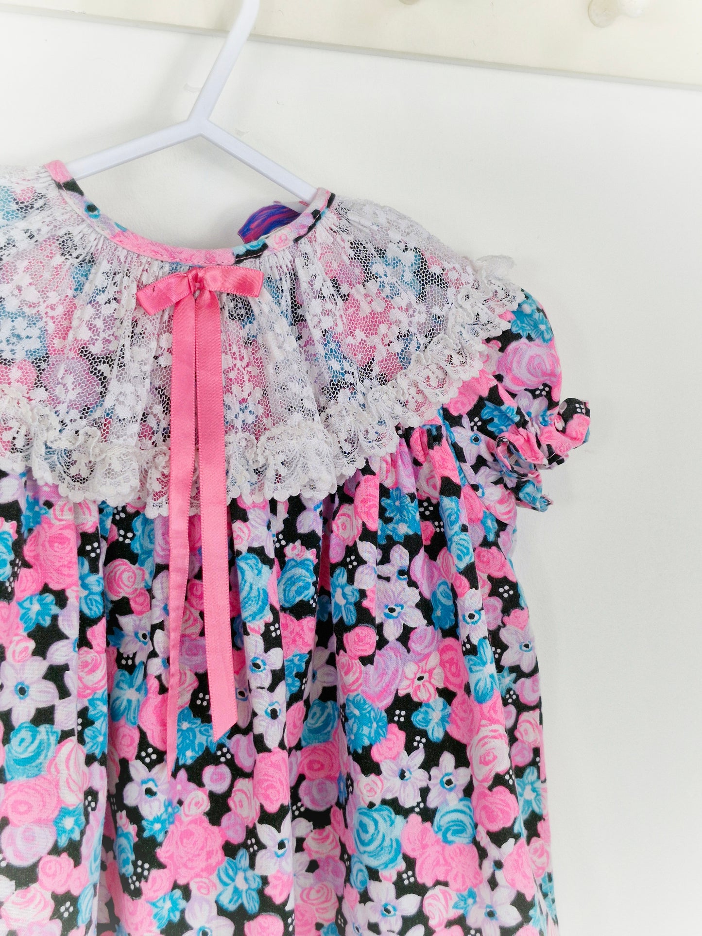 12-18 months. Bright, floral Roanna dress with lace bib and pink ribbon