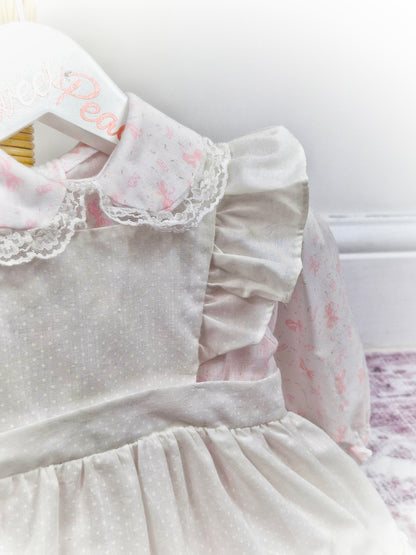 12-18 months. White dress with pink bows print and white pinny, embroidered with flowers
