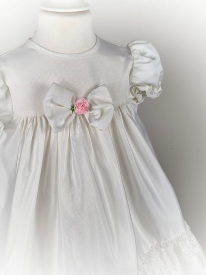 3 years. White vintage frilly dress with lace, puff sleeves and pink centred flower