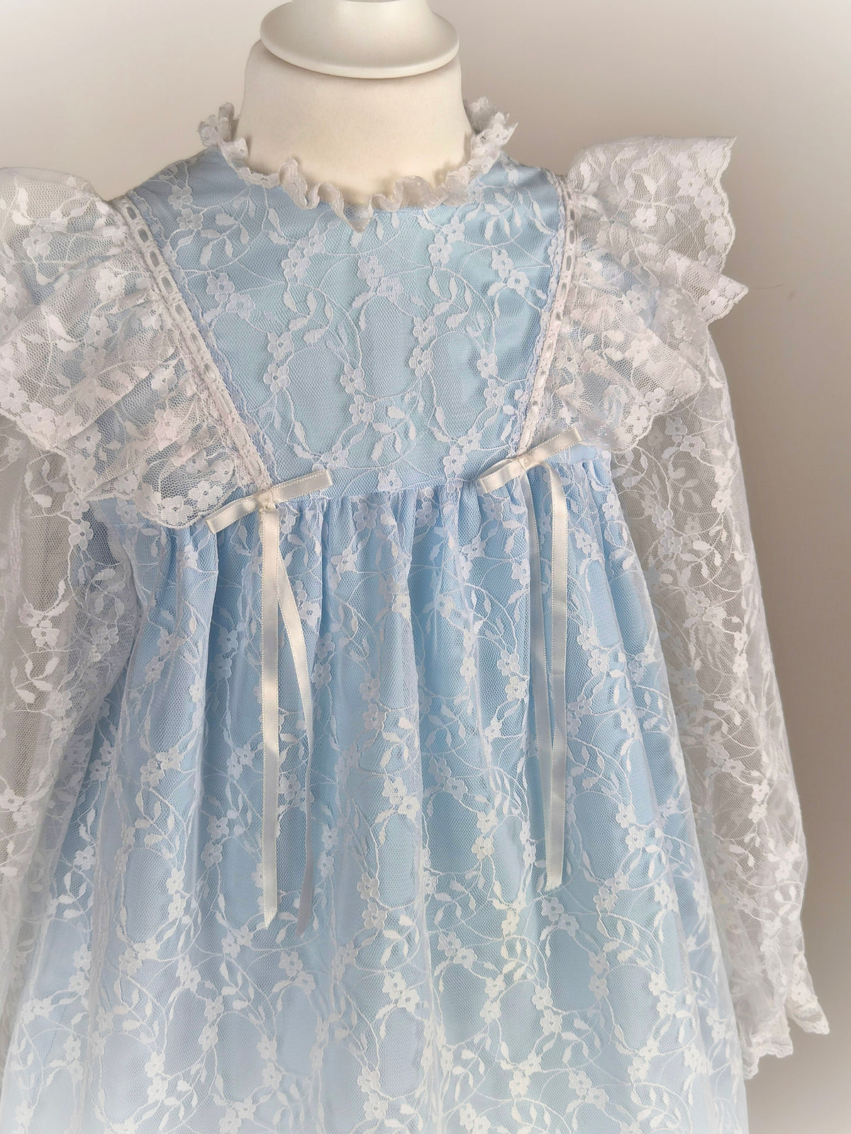 6 years. Blue vintage dress with white lace overlay, flutter shoulders and ribbon bows