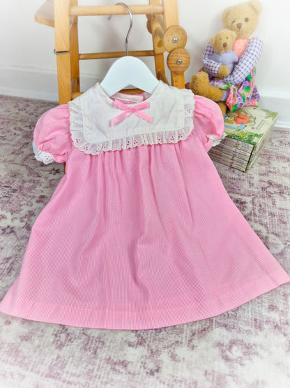 12-18 months. Pink and white striped vintage dress with white bib eyelet trim and pink satin bow