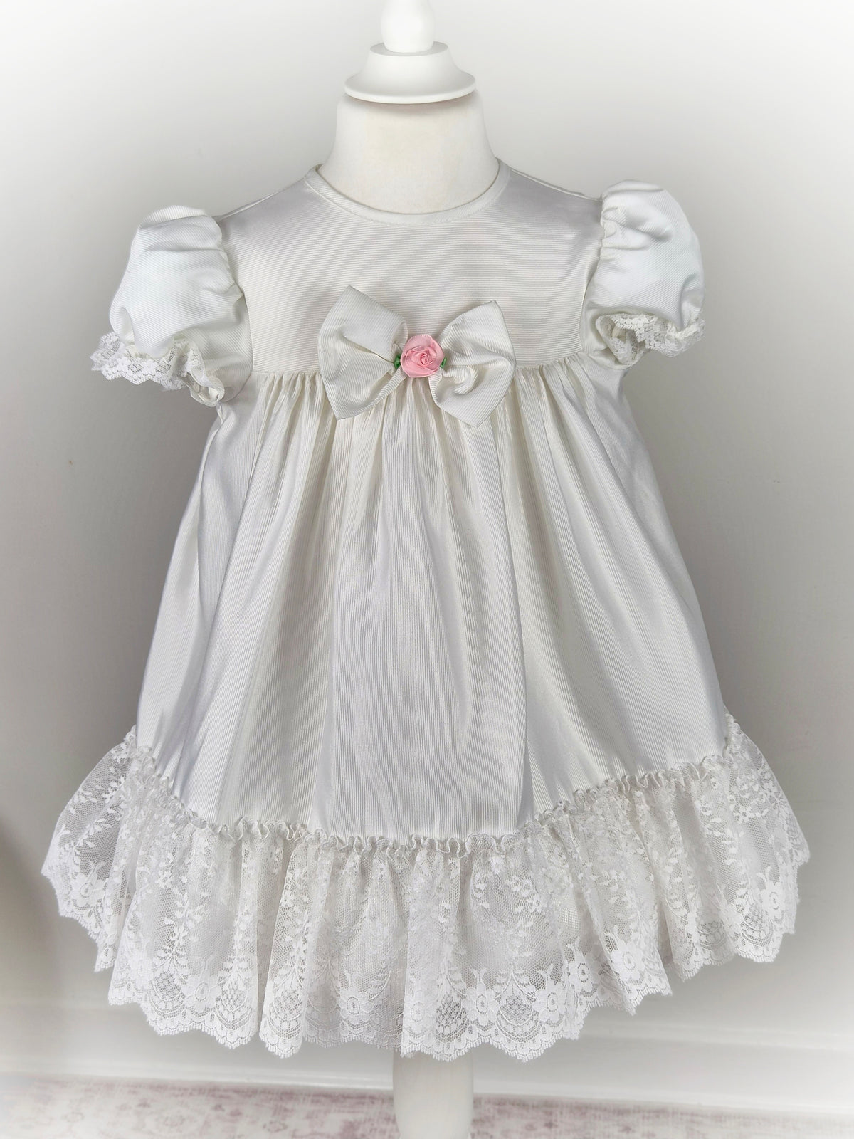 3 years. White vintage frilly dress with lace, puff sleeves and pink centred flower