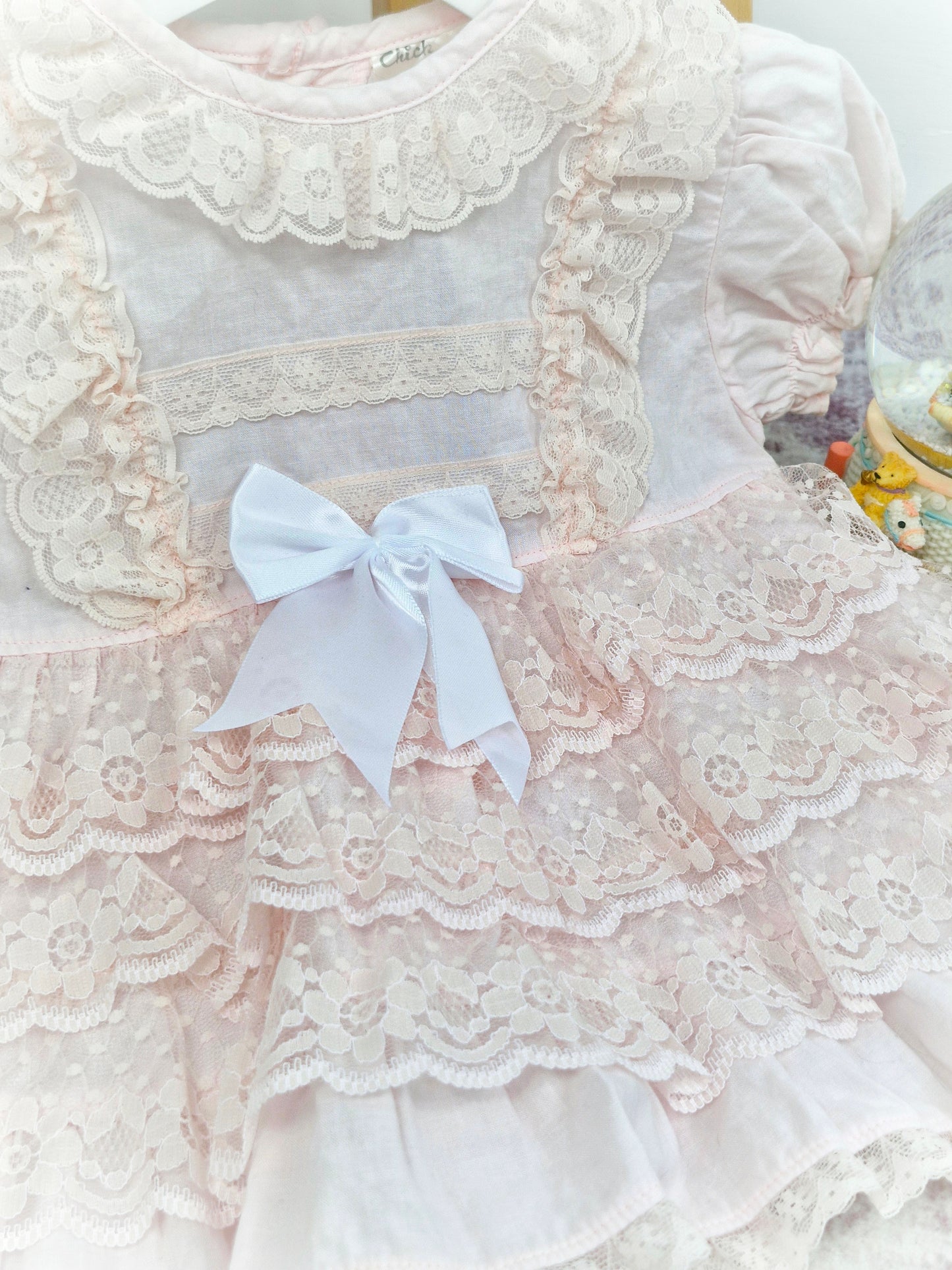 12 months. Pink vintage frilly dress with lace ruffles, puff sleeves and white ribbon