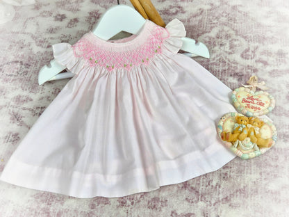 6 months. Vintage inspired pink smock dress with flutter sleeves and pink embroidery
