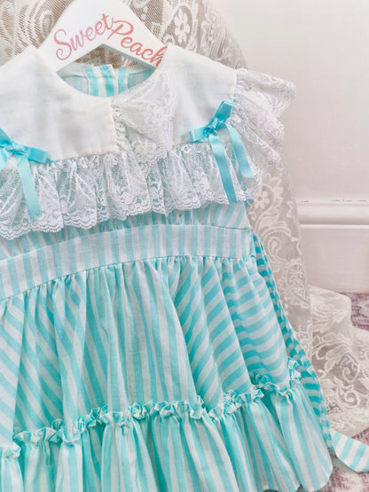 2 years. Mint and white sleeveless, striped dress with white bib, lace and bows