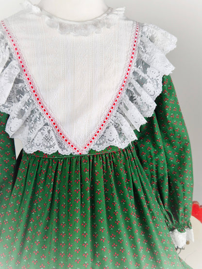 5-6 years. Forest green vintage Bryan prairie dress with red design and white frilly lace bib