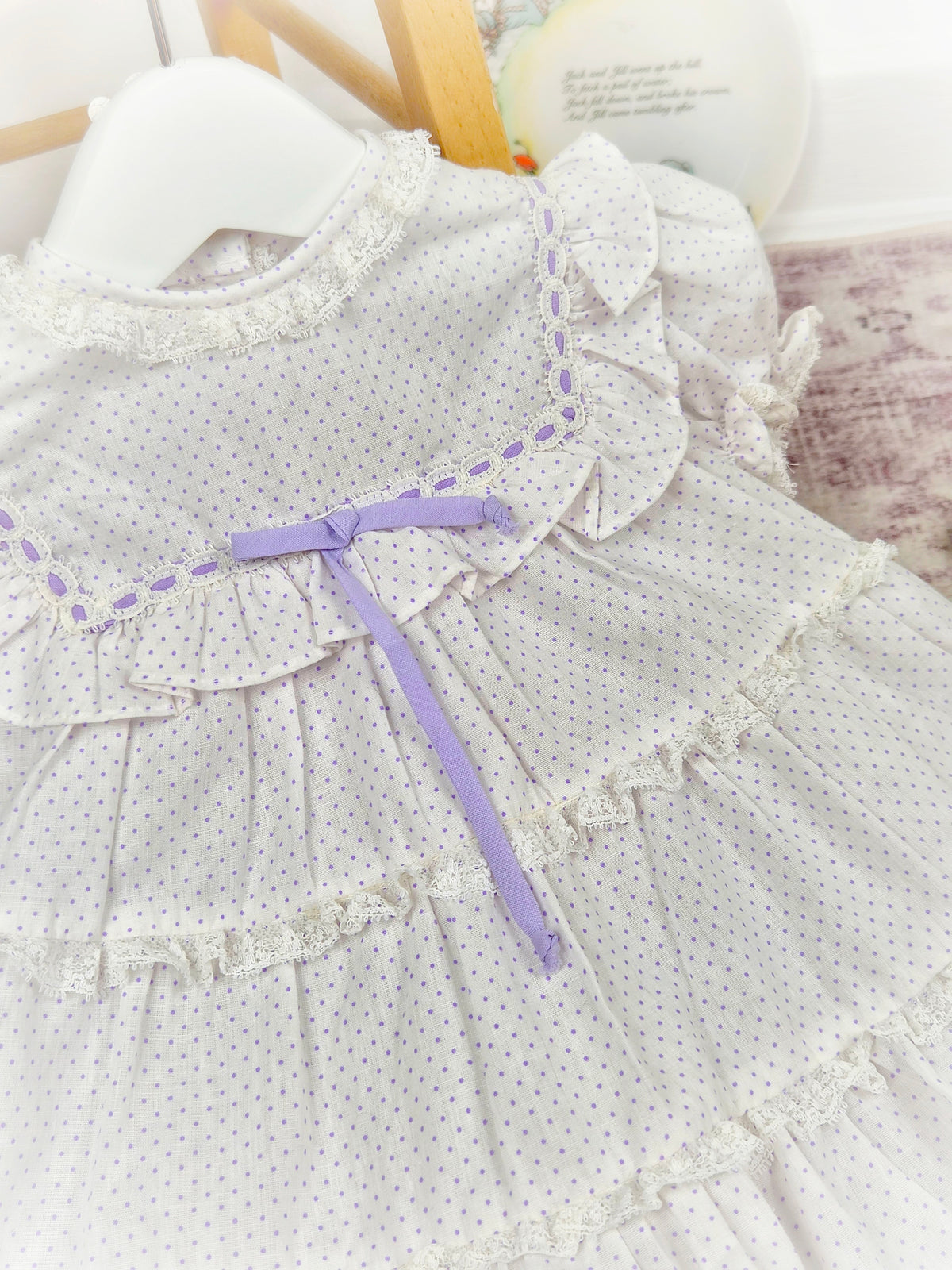 12 months. White vintage dress with lilac polka dots and ribbon, tiers and lace trim