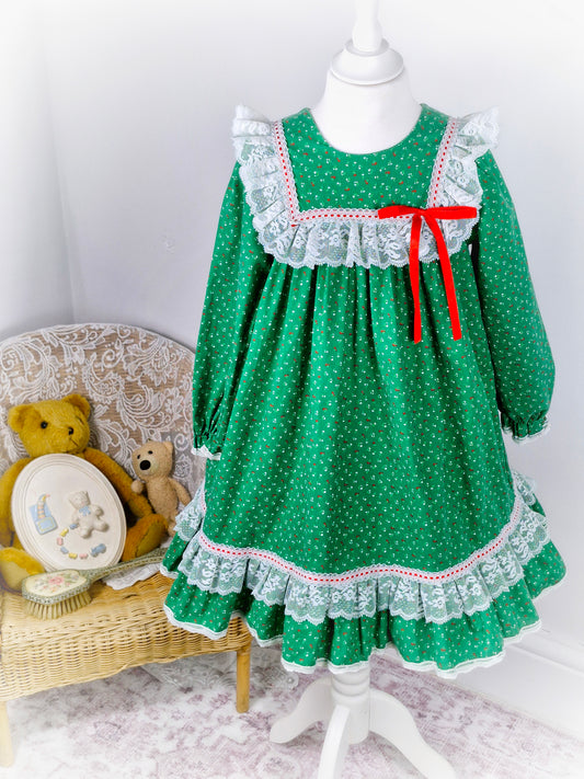6 years. Green vintage Bryan with red and white floral print, white lace details and red ribbon