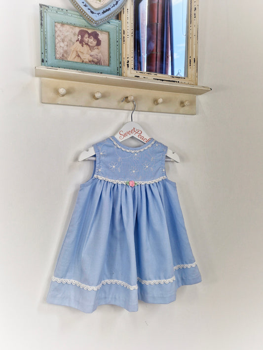 2 years. Blue sleeveless dress with white details and pink rosette