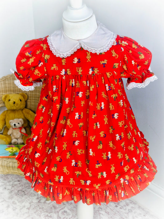 2-3 years. Red dress with cute teddy print, white collar and puff sleeves.