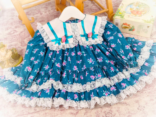 12 months. Teal floral vintage dress with white collar, lace trim, ribbon bows and rosettes
