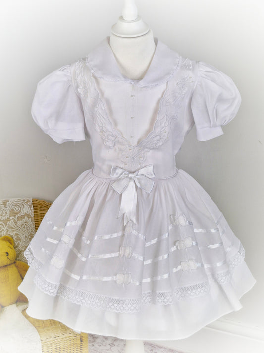 6 years. White dress with ribbon and butterfly details.