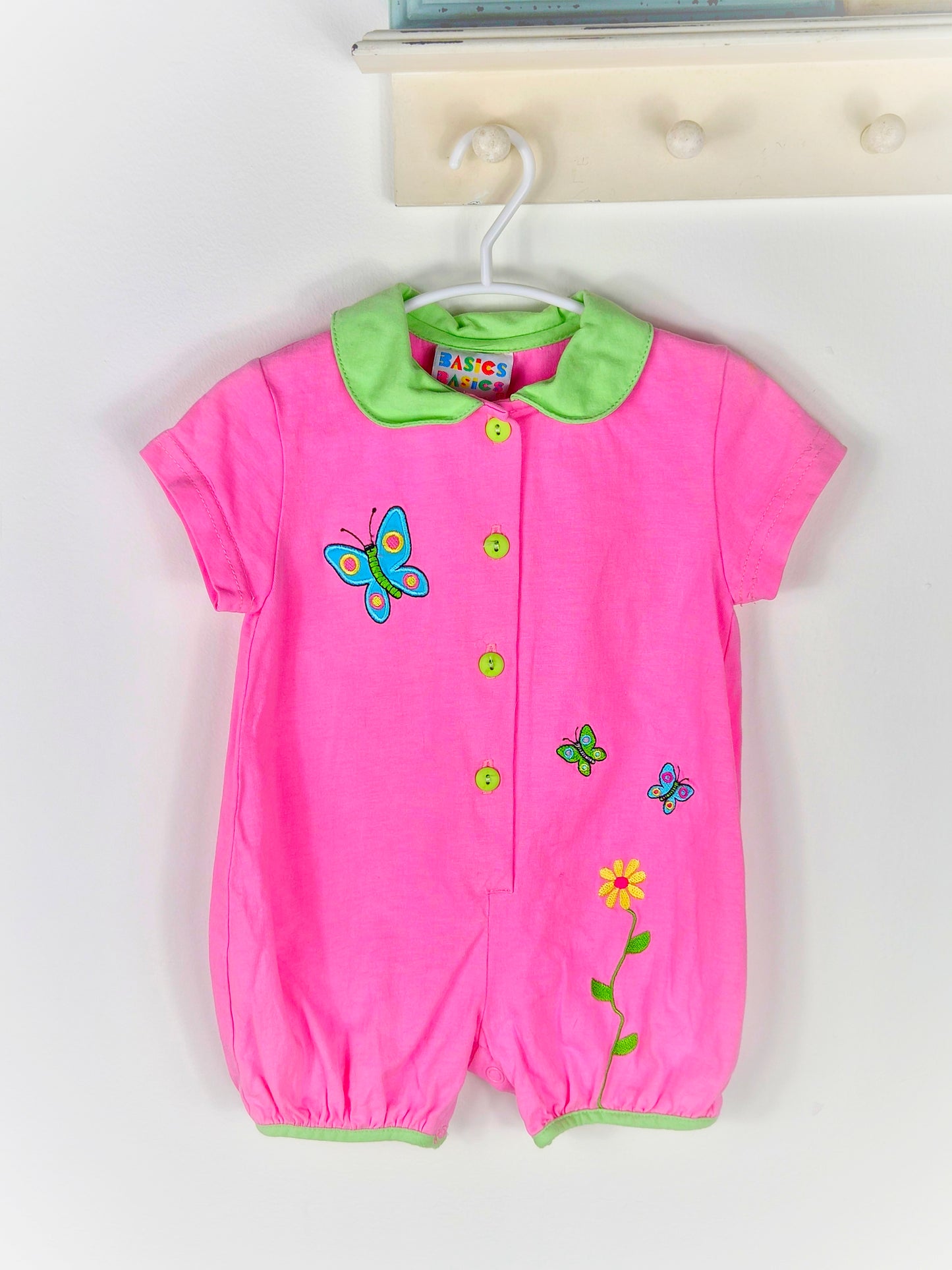 9-12 months. Pink romper with green collar and buttons, embroidered butterflies and flowers