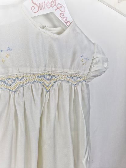 Best fit 2-3 years. Ivory satin unisex romper with lemon and blue smock embroidery