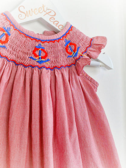 9-12 months. Vintage inspired, red and white striped dress with flutter sleeves, smocking and embroidered anchors